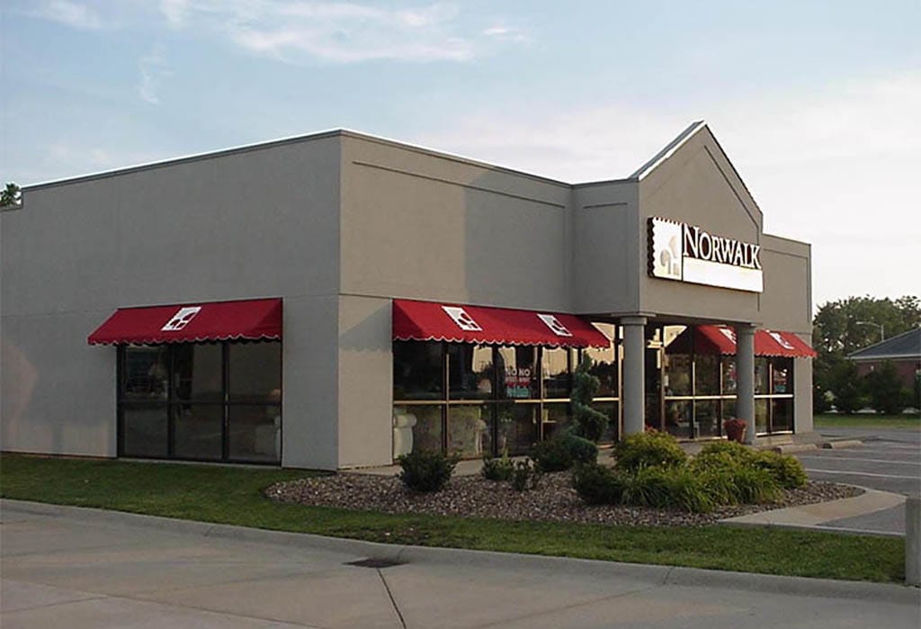 Commercial building with red and black window awnings.