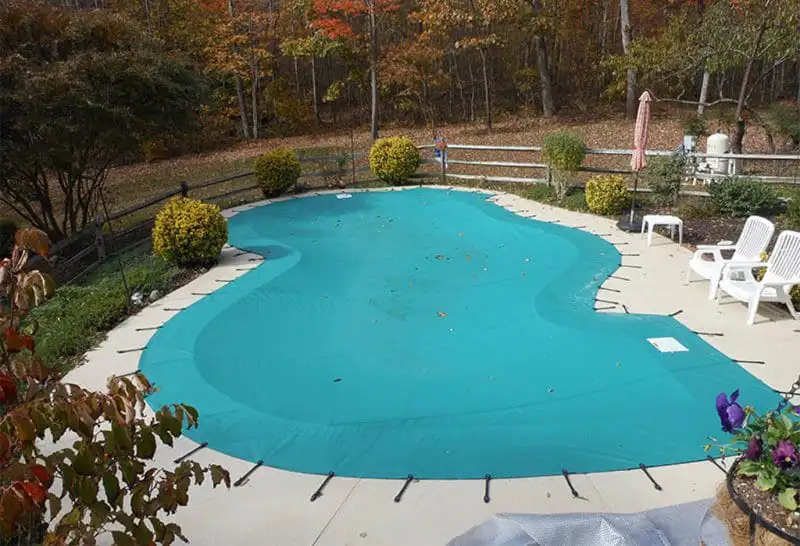 Backyard swimming pool with turquoise water and stone landscaping.