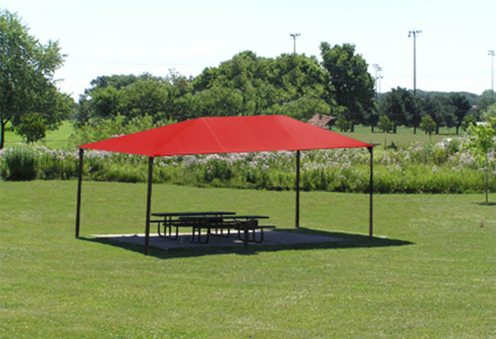 Red canopy providing shade over picnic tables on grassy field.
